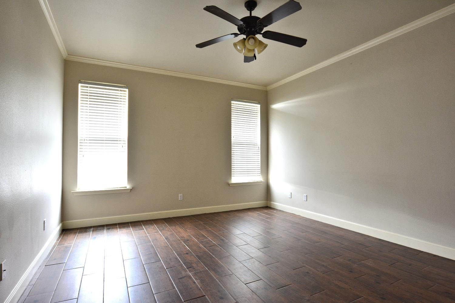 2623 112th Street Lubbock, TX 79423 - Photo 13 of 16 an empty room with wooden floor fan and windows