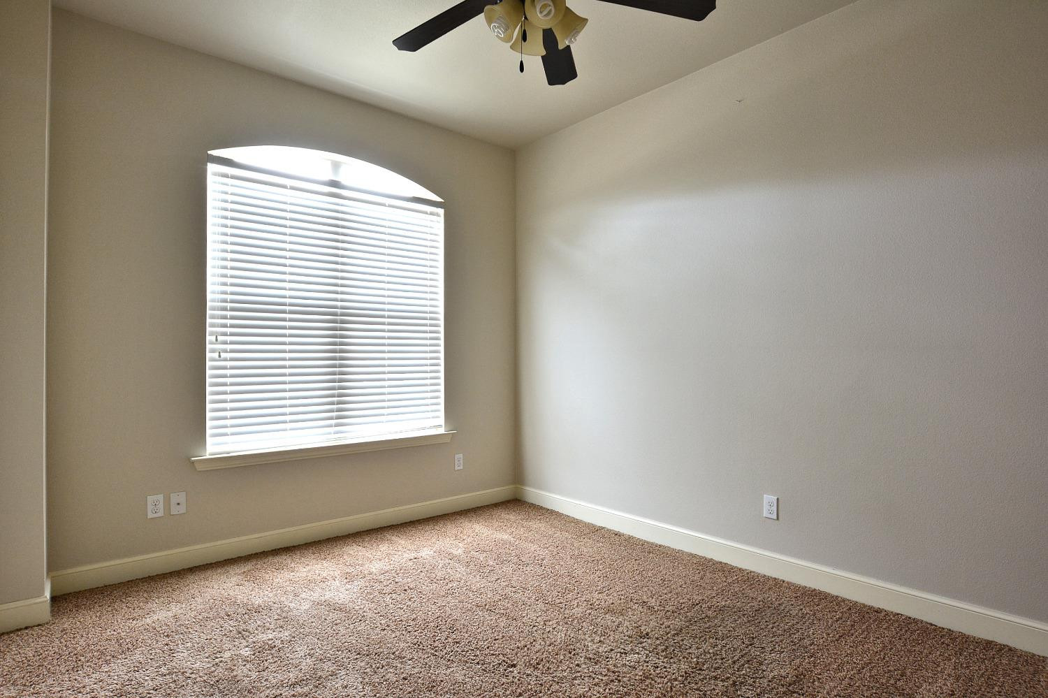2623 112th Street Lubbock, TX 79423 - Photo 14 of 16 an empty room with a window and a ceiling fan