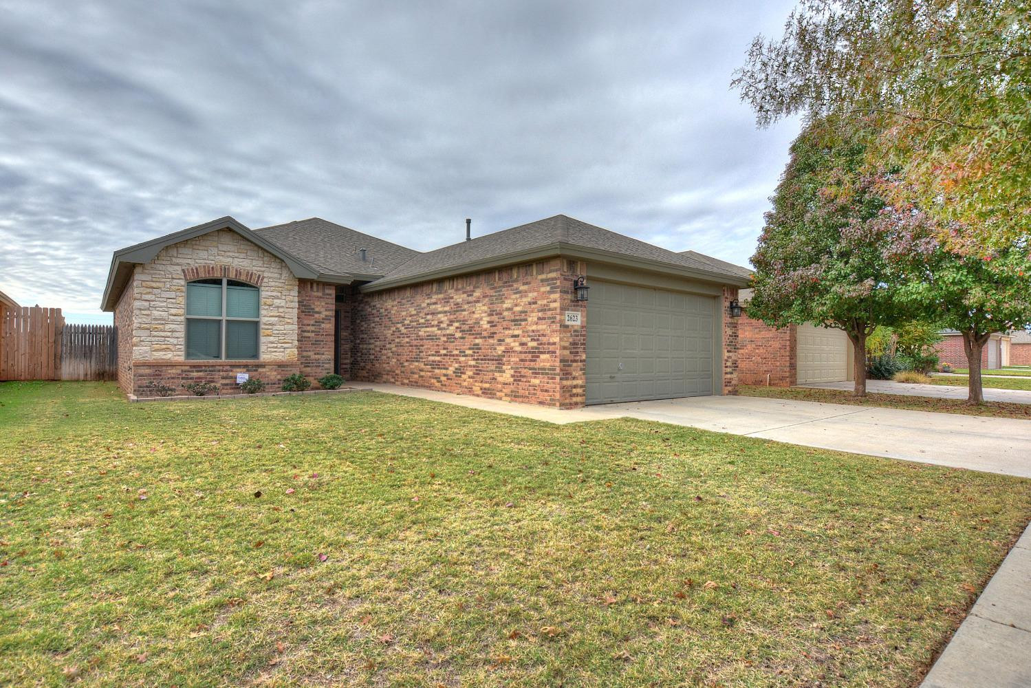 2623 112th Street Lubbock, TX 79423 - Photo 2 of 16 a view of a house with a yard and garage