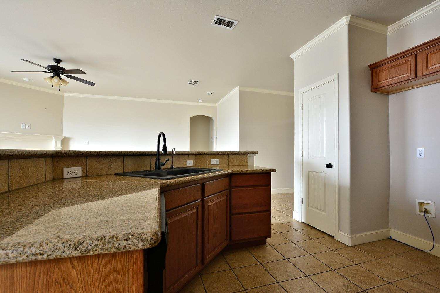 2623 112th Street Lubbock, TX 79423 - Photo 9 of 16 a kitchen with a sink refrigerator and cabinets