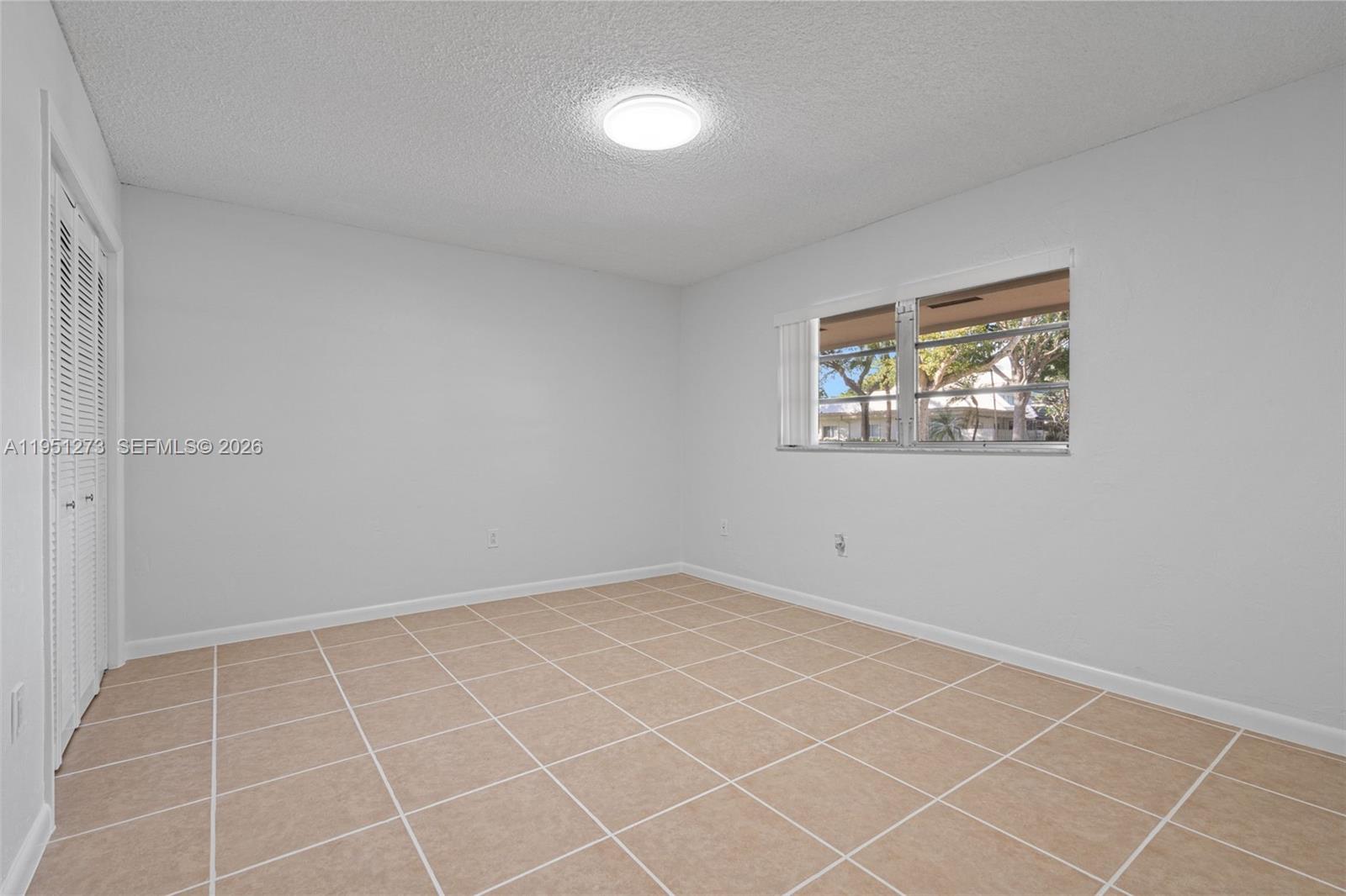 8134 Southwest 83rd Street Miami, FL 33143 - Photo 10 of 15 an empty room with a white wall and a window