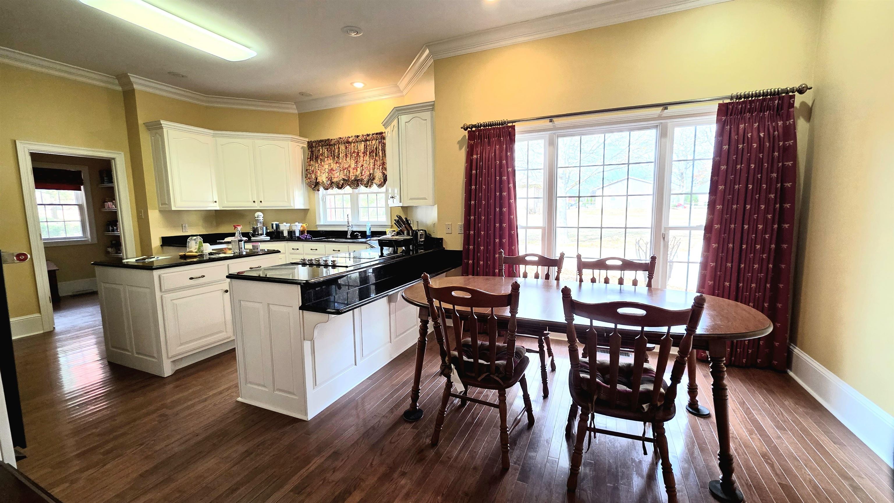 3070 Caney Branch Road Adamsville, TN 38310 - Photo 7 of 24 a kitchen with a table chairs stove and cabinets