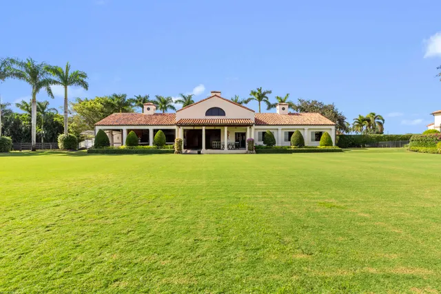 a view of a garden with a bench in front of house