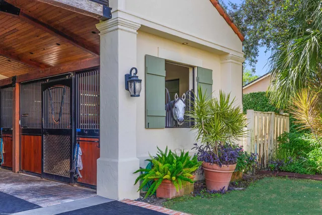 a front view of a house with a garden and trees
