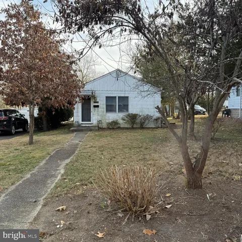 a white house that has a tree in front of it