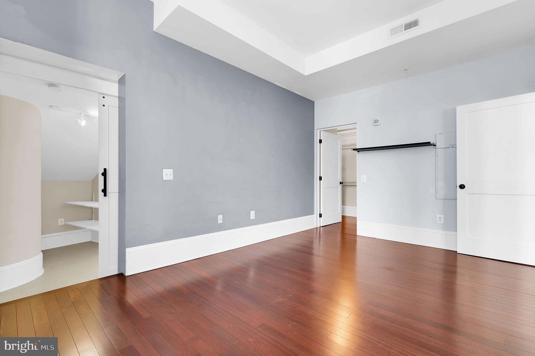 9610 Dewitt Drive, Unit SH205 Silver Spring, MD 20910 - Photo 15 of 59 a view of an empty room with wooden floor and a bathroom