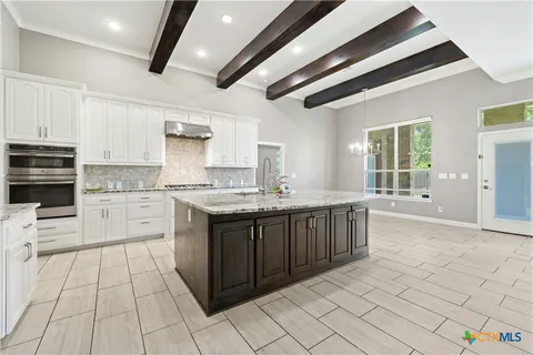 a large white kitchen with cabinets