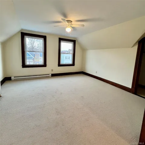 an empty room with windows and ceiling fan