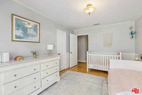 a spacious bedroom with a bed and a baby crib