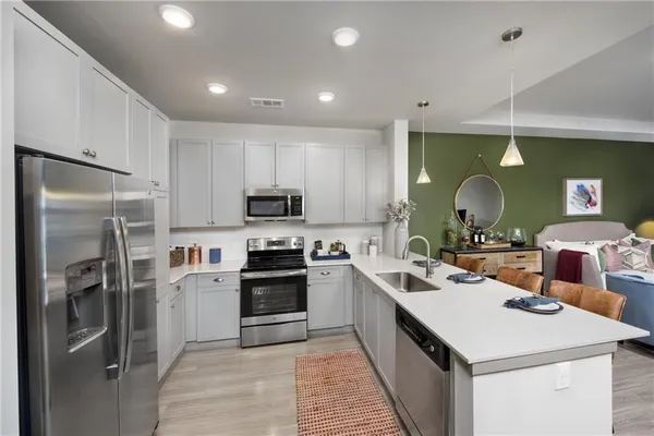 a kitchen that has a lot of cabinets a sink and appliances
