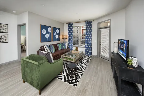 a living room with furniture a piano and a flat screen tv