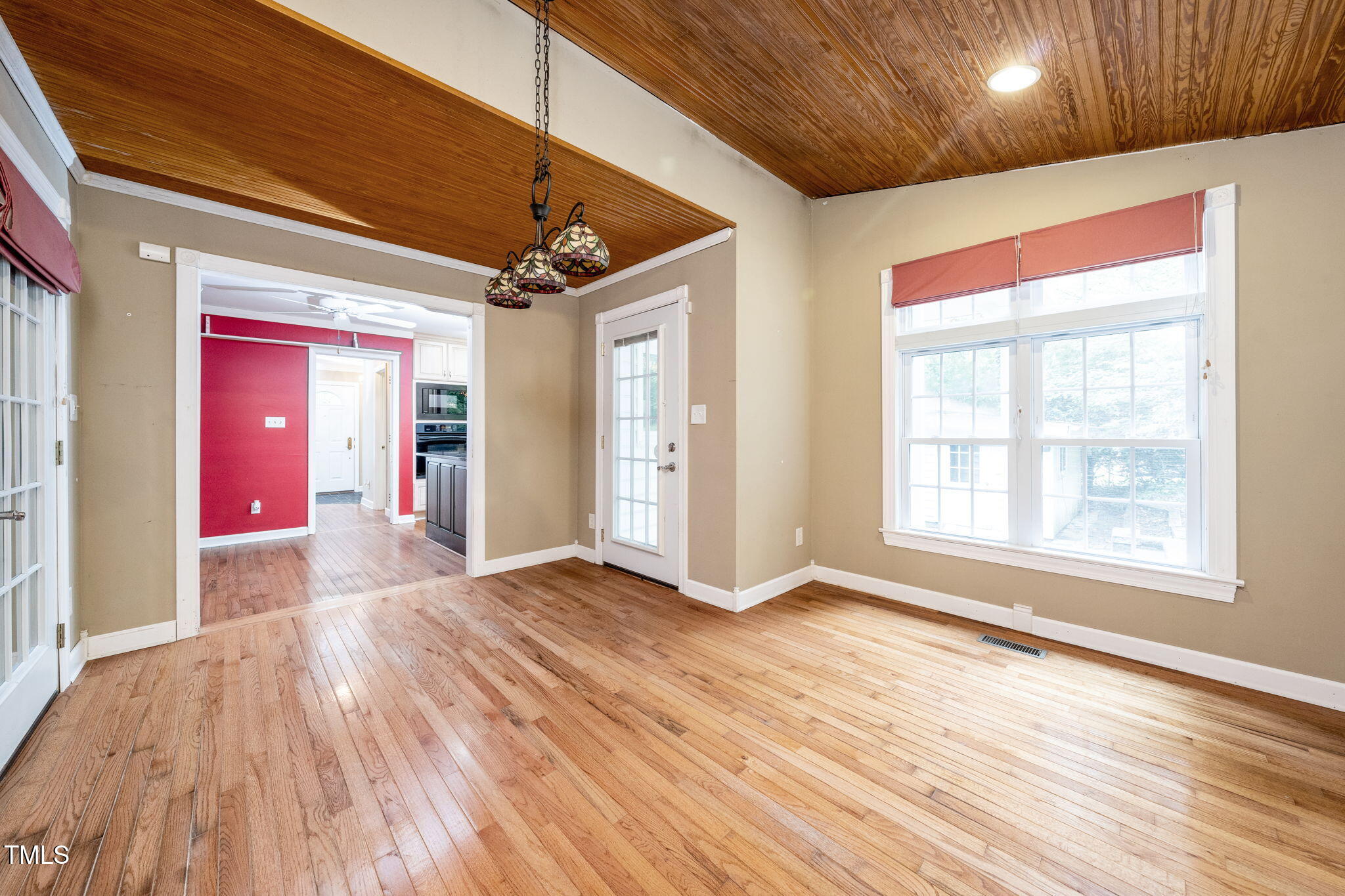 6221 Rushingbrook Drive Raleigh, NC 27612 - Photo 12 of 30 a view of an empty room with wooden floor and a window