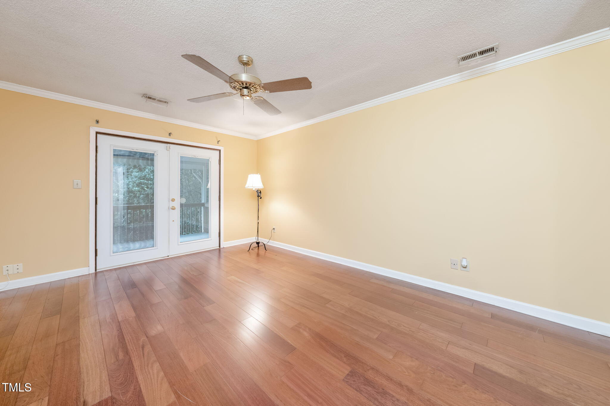 6221 Rushingbrook Drive Raleigh, NC 27612 - Photo 17 of 30 a view of an empty room with wooden floor and a window
