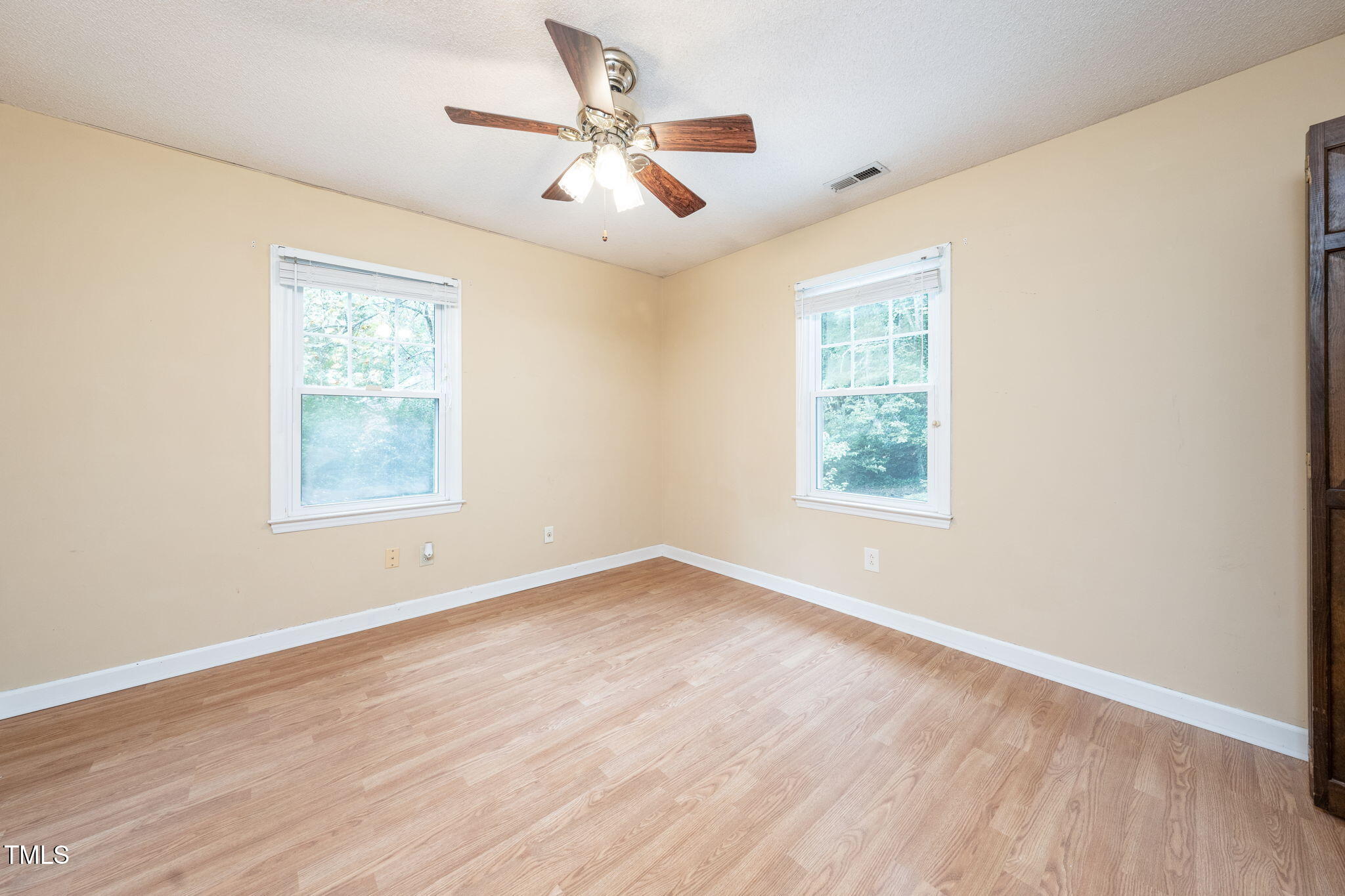 6221 Rushingbrook Drive Raleigh, NC 27612 - Photo 23 of 30 a view of an empty room with a window and wooden floor