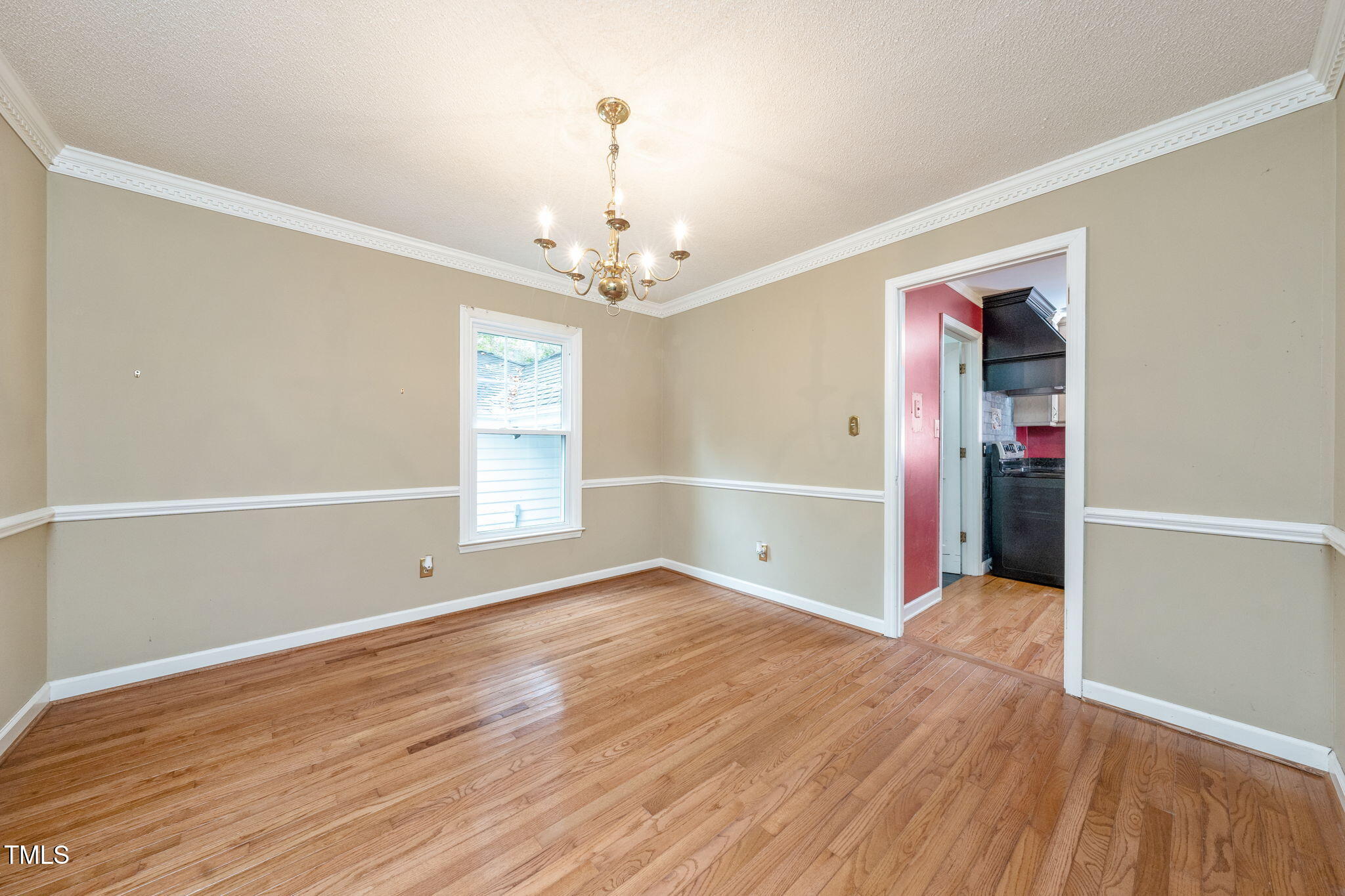 6221 Rushingbrook Drive Raleigh, NC 27612 - Photo 4 of 30 an empty room with wooden floor chandelier and windows