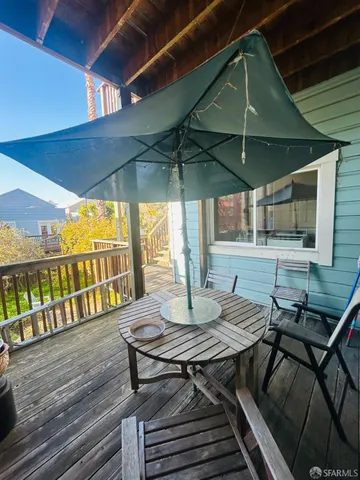 a view of a patio with table and chairs under an umbrella