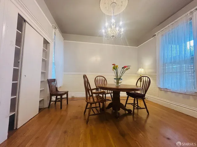 a view of a dining room with furniture wooden floor and chandelier