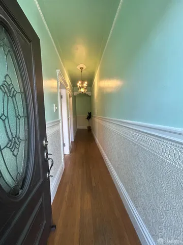 a view of a hallway with wooden floor