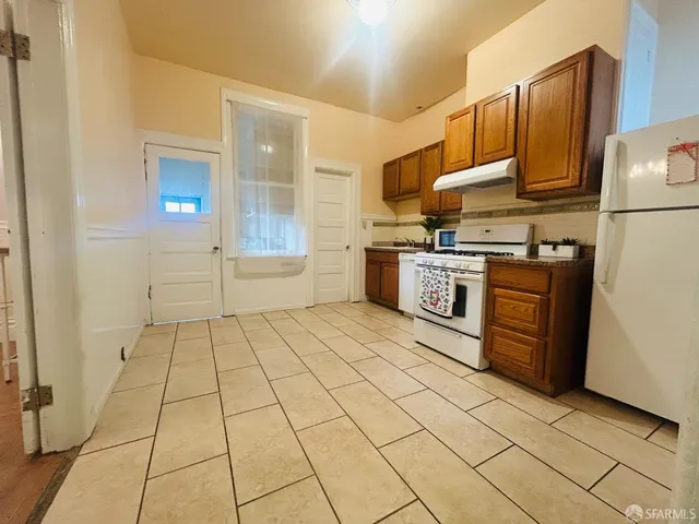 a kitchen with stainless steel appliances granite countertop a stove a sink and a refrigerator
