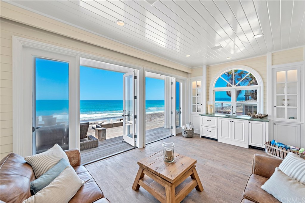 a living room with furniture a large window and wooden floor