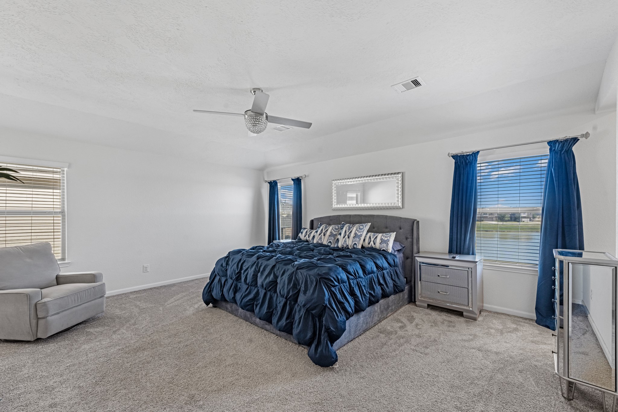 5126 Avondale Rise Street Katy, TX 77493 - Photo 18 of 28 The primary bedroom is generously sized, creating a tranquil and spacious retreat that offers ample room for relaxation. Featuring plush carpet, high ceilings, fresh paint, and large windows that lets in natural lighting throughout the day.