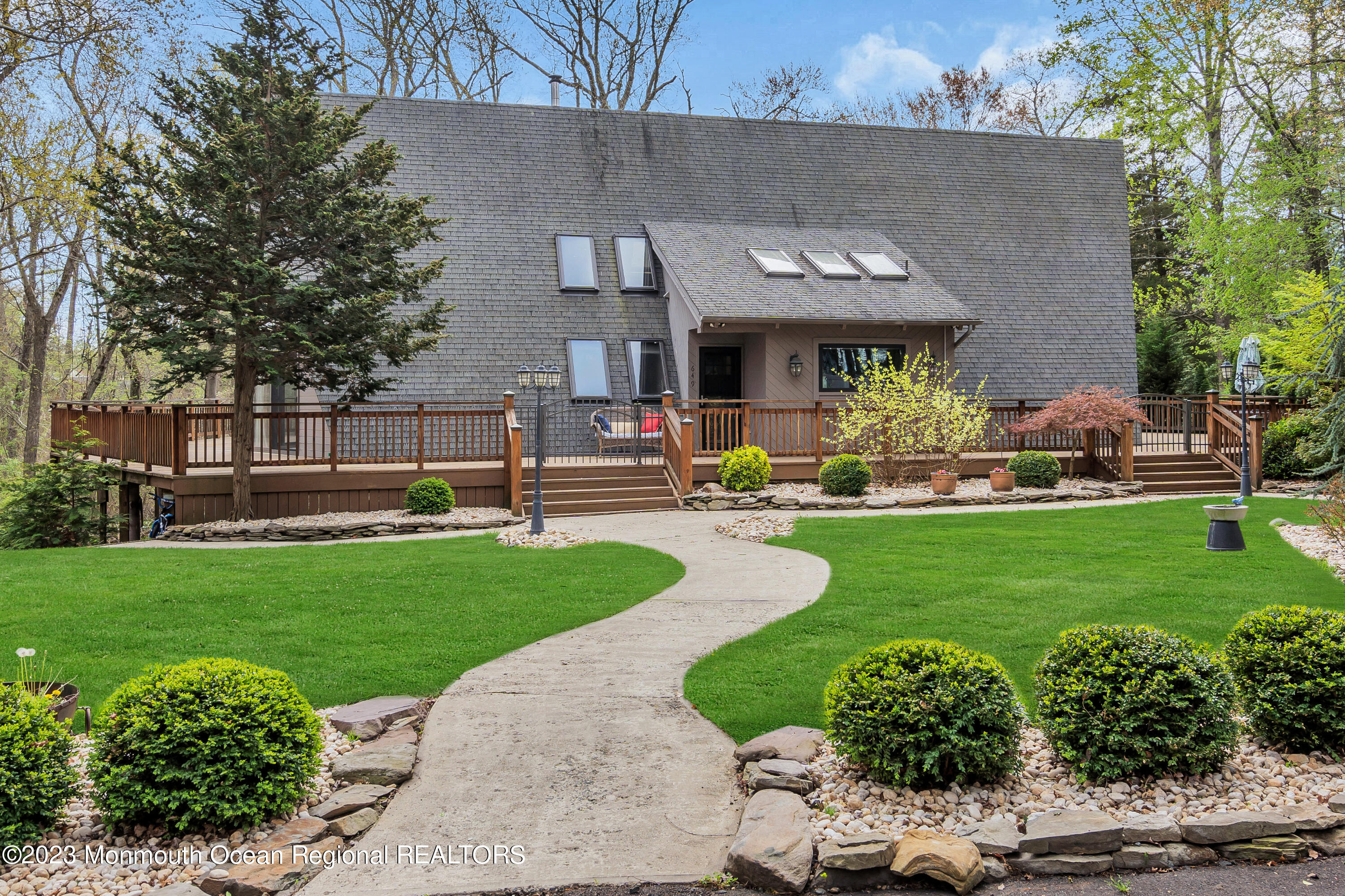 a front view of a house with garden and sitting area