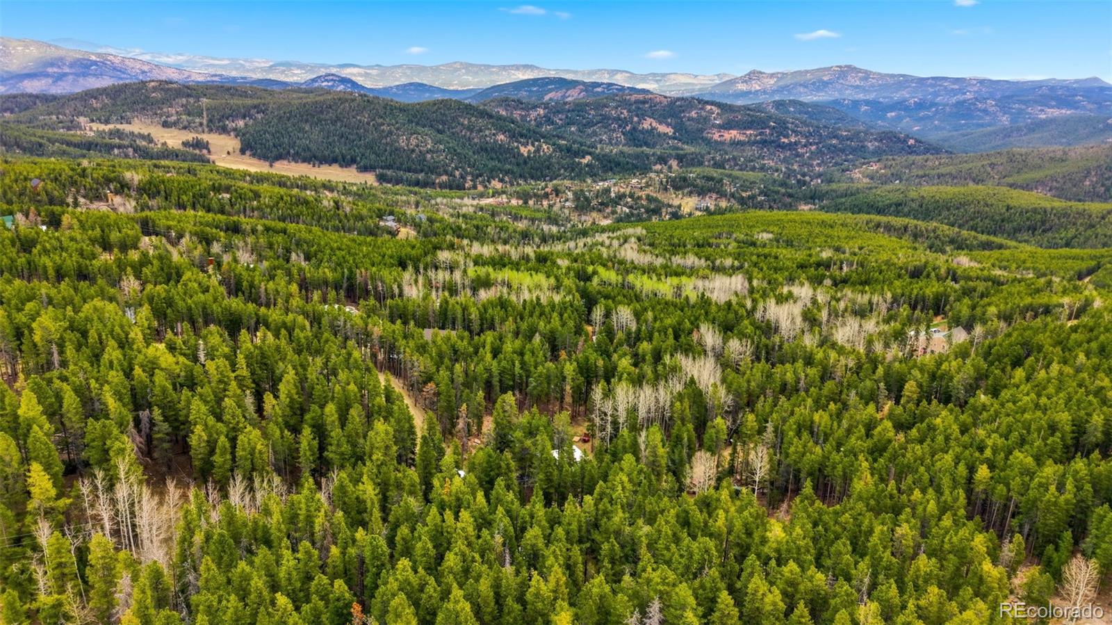 154 Apache Road Evergreen, CO 80439 - Photo 27 of 30 a view of a lush green hillside and a building