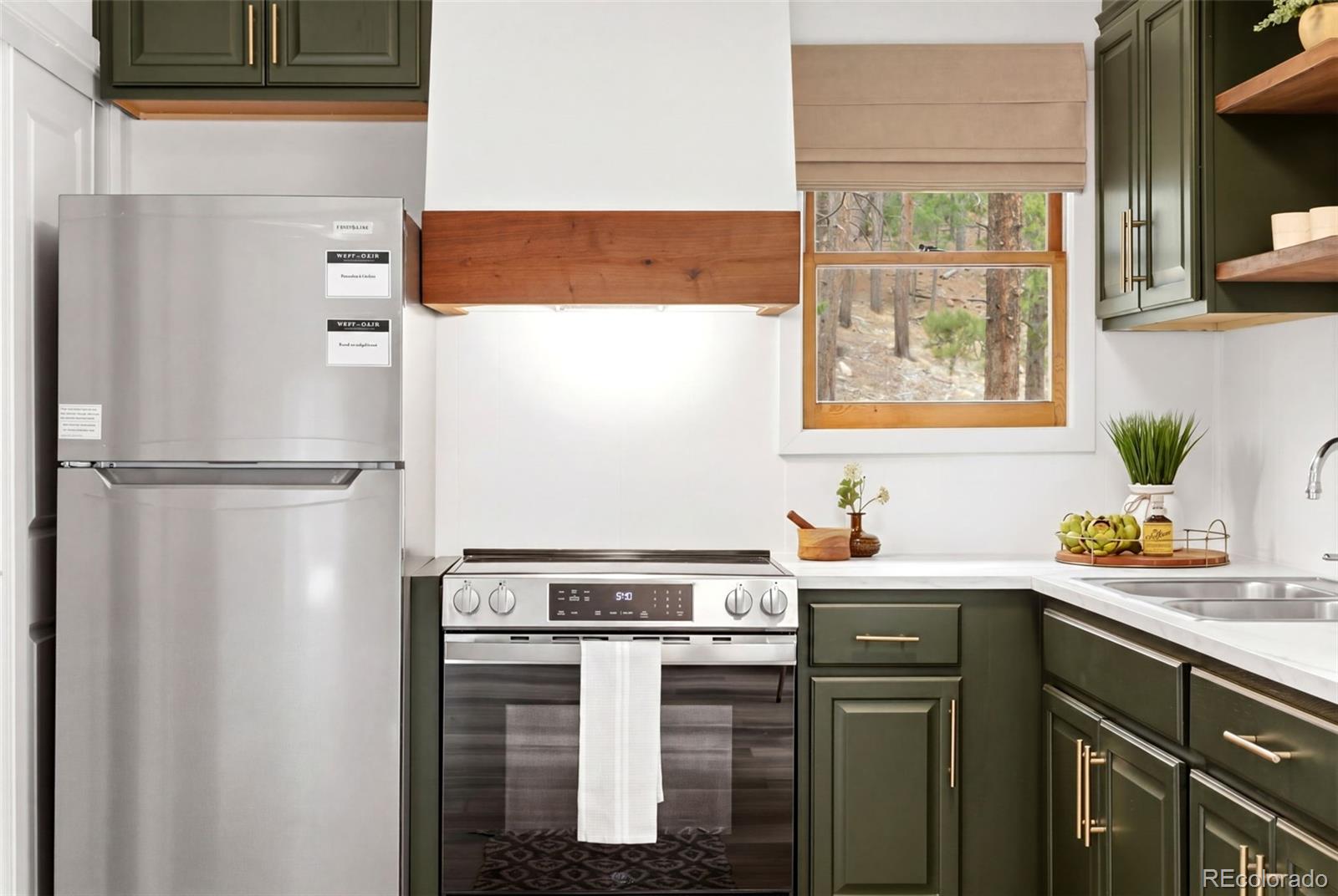 154 Apache Road Evergreen, CO 80439 - Photo 9 of 30 a kitchen with a refrigerator and a sink