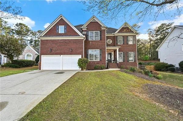 a front view of a house with a yard and garage