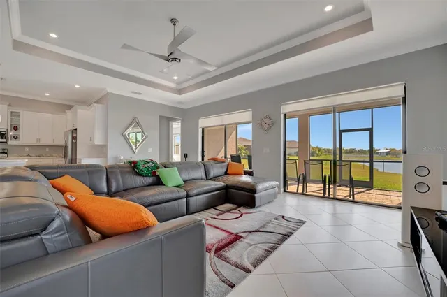 a living room with furniture a flat screen tv and a large window