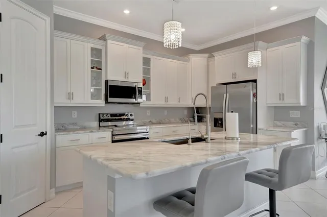 a kitchen with stainless steel appliances granite countertop a stove a sink a microwave a refrigerator and cabinets