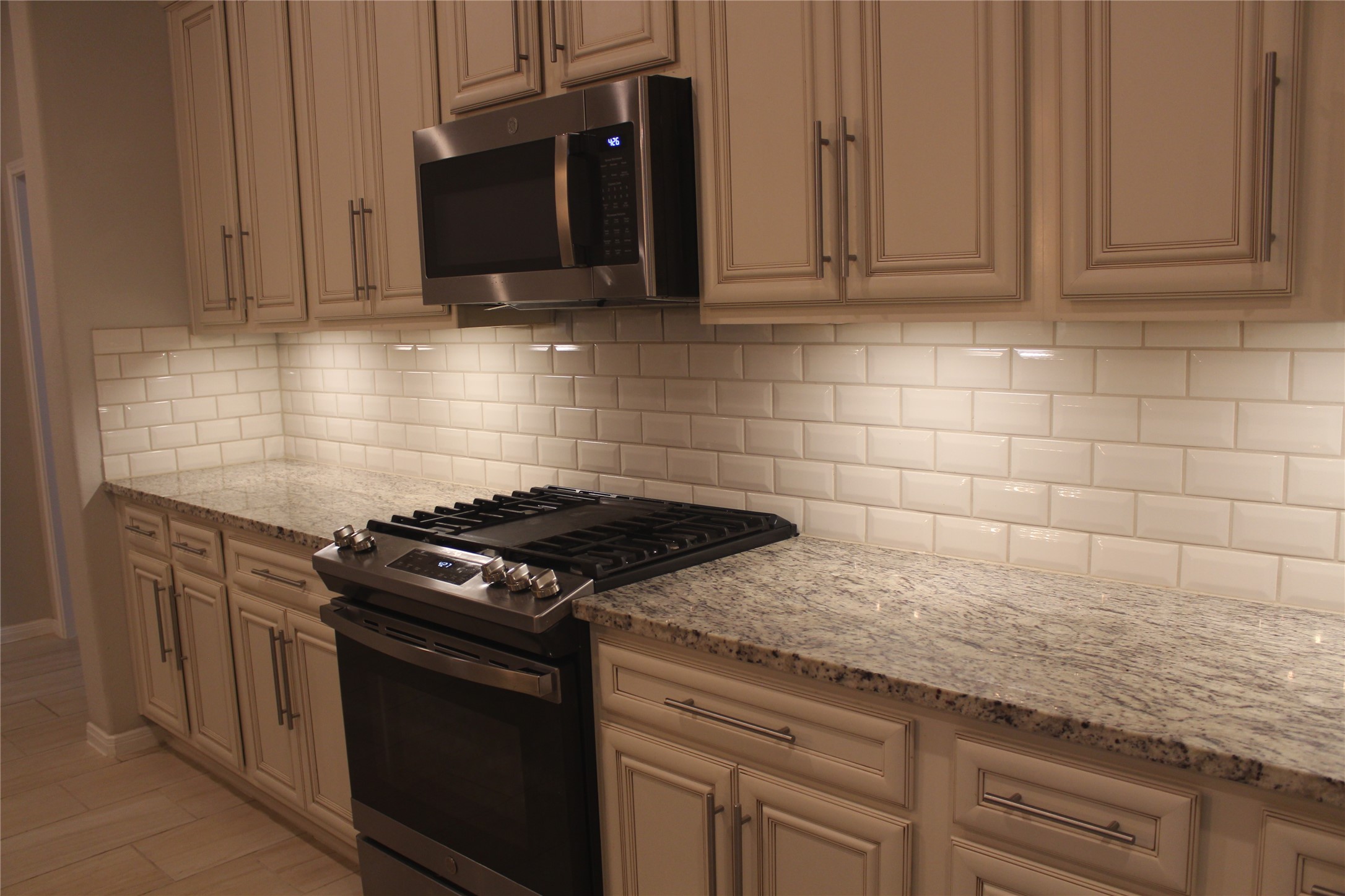 14200 Wallowa Ridge Lane Conroe, TX 77384 - Photo 6 of 22 a kitchen with granite countertop stainless steel appliances a stove a microwave and cabinets