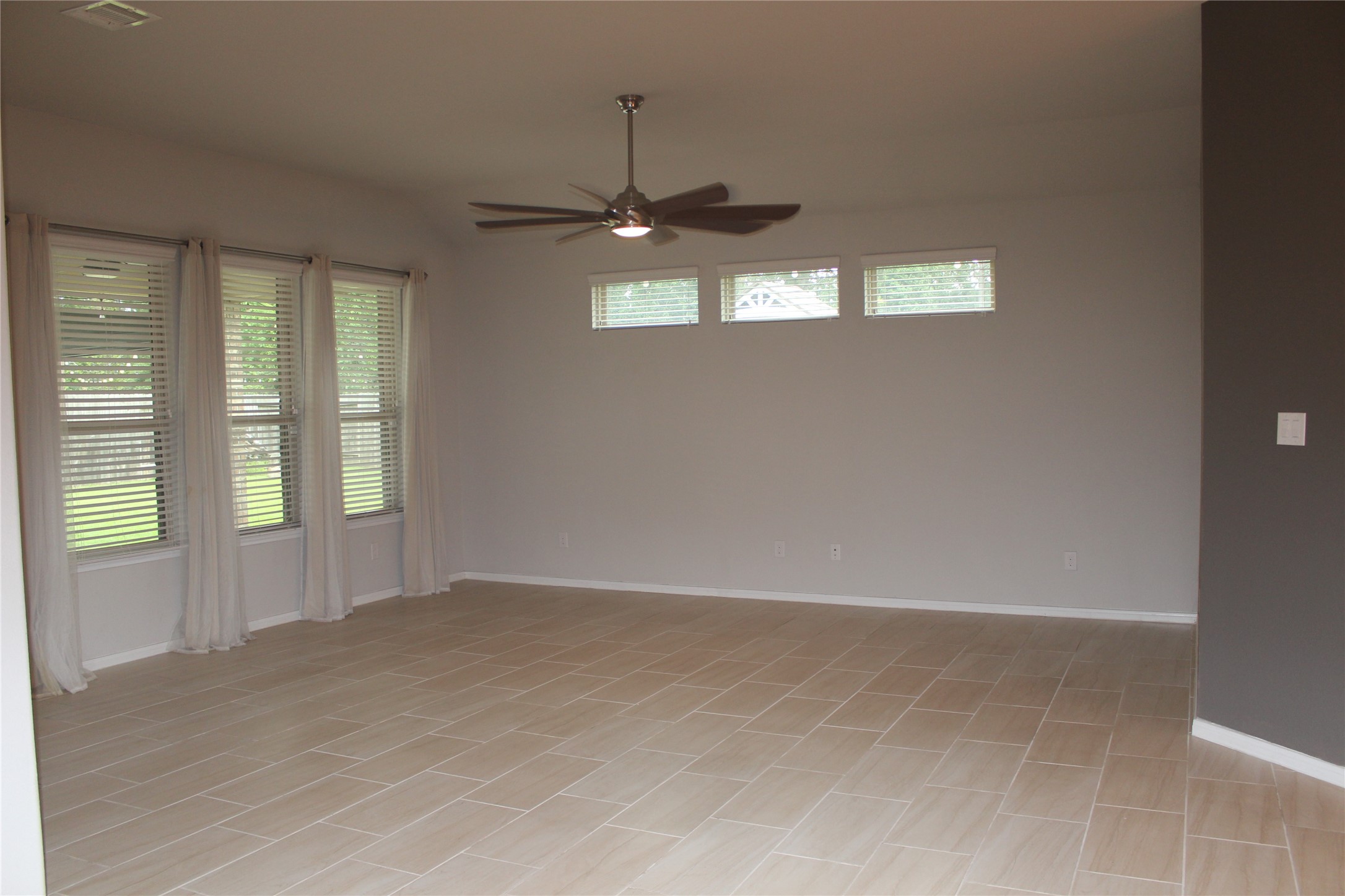 14200 Wallowa Ridge Lane Conroe, TX 77384 - Photo 8 of 22 an empty room with chandelier fan and windows