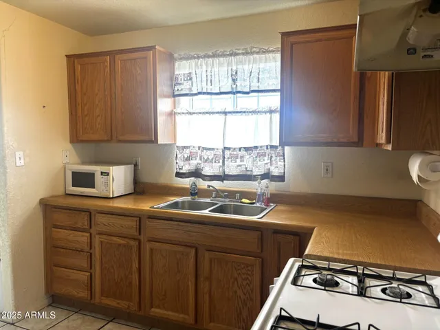 a kitchen with a sink stove top oven and cabinets