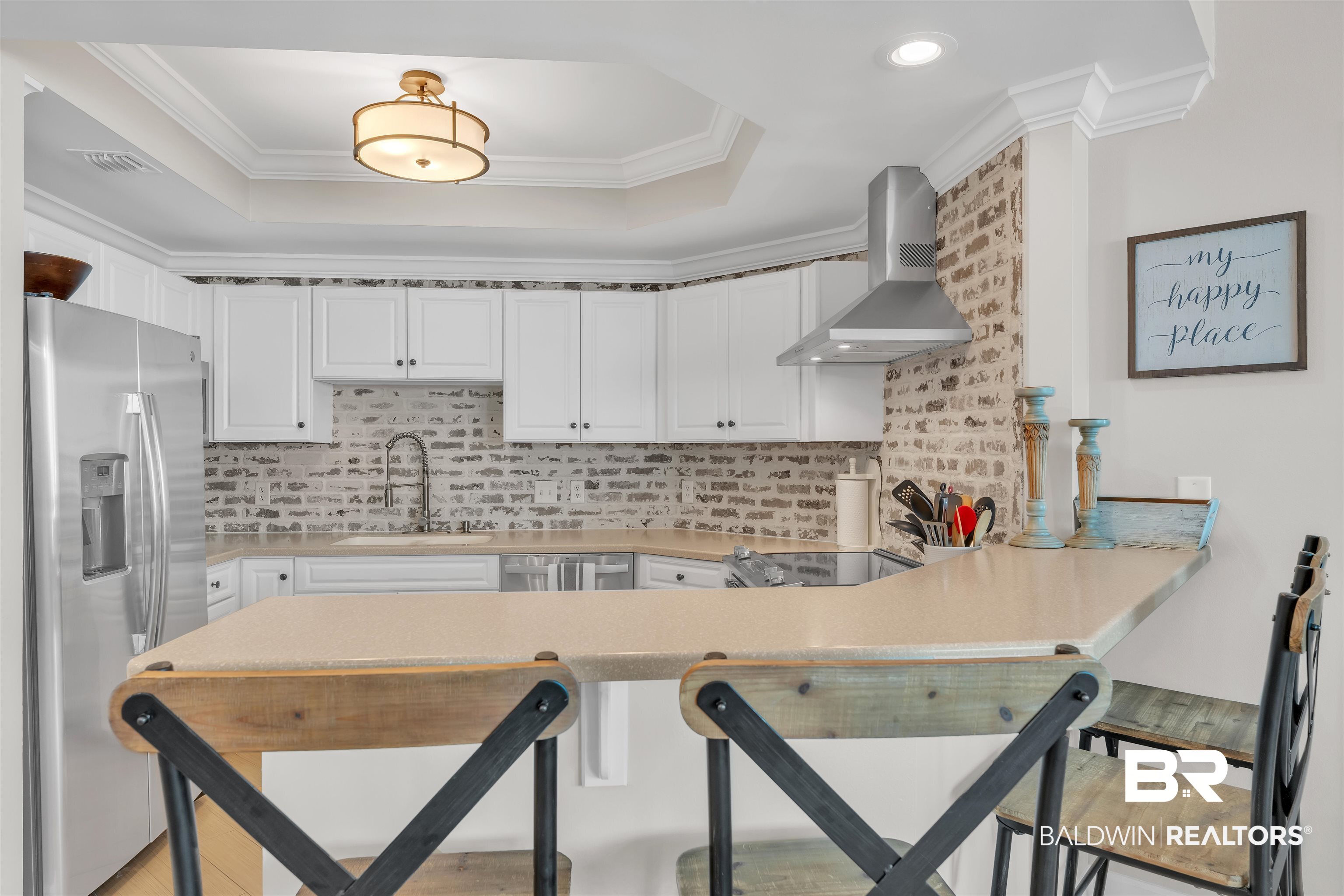 27582 Canal Road, Unit 2605 Orange Beach, AL 36561 - Photo 10 of 41 Kitchen with stainless steel fridge with ice dispenser, wall chimney range hood, a sink, a peninsula, and a tray ceiling