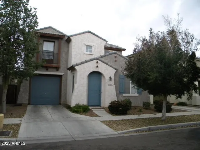 a view of a house with a yard and large tree