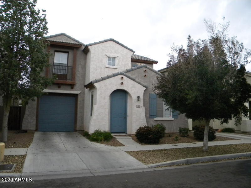 a view of a house with a yard and large tree