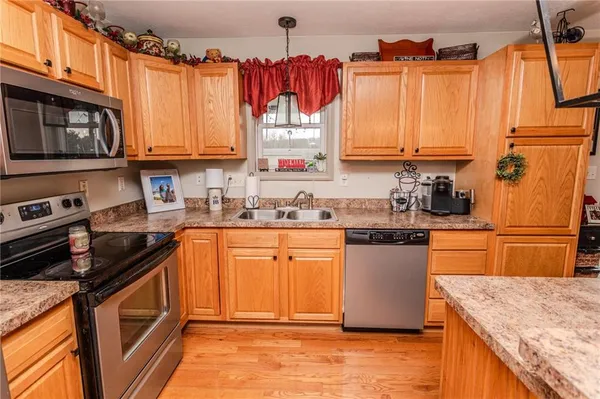 a kitchen with stainless steel appliances granite countertop a sink a stove top oven a counter space and cabinets