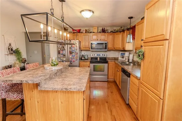 a kitchen with stainless steel appliances granite countertop sink stove and refrigerator