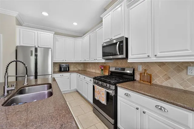 a kitchen with granite countertop white cabinets and a sink