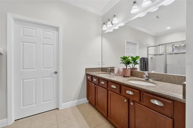a bathroom with a granite countertop double vanity and a mirror