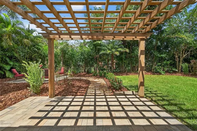 a view of a patio with table and chairs potted plants and a large tree