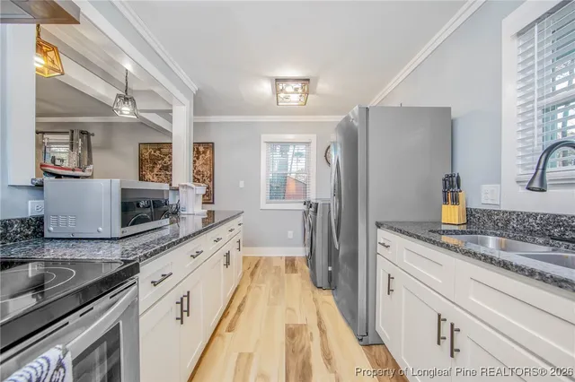 a large kitchen with a sink and stainless steel appliances