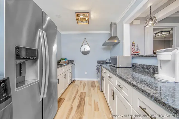 a kitchen with stainless steel appliances granite countertop a refrigerator and a stove