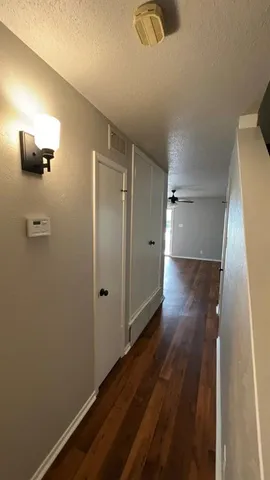 a view of a hallway with wooden floor