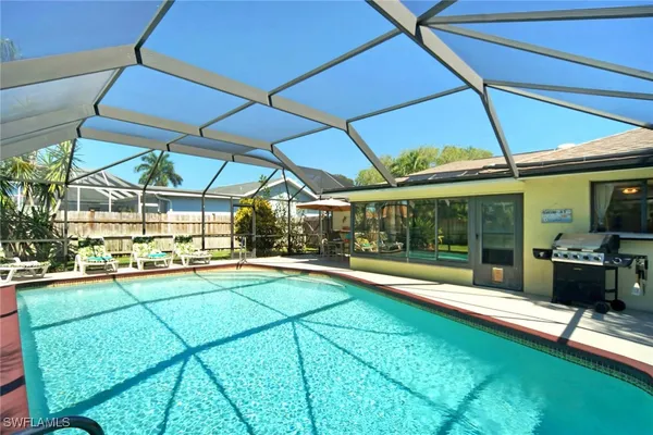 a view of a swimming pool with a patio and a yard