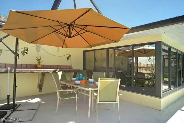 a patio with a table and chairs under an umbrella