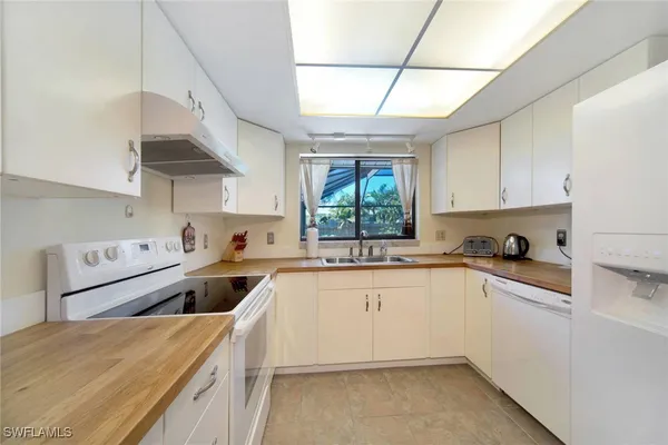 a kitchen with stainless steel appliances granite countertop a sink a stove and a refrigerator