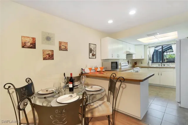 a kitchen with stainless steel appliances granite countertop a dining table and chairs