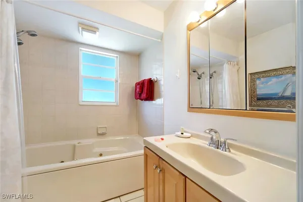 a bathroom with a sink vanity tub and shower